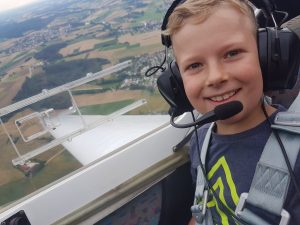 Ein Ferienpass - Kind fliegt im Motorsegler über der Hallertau mit.