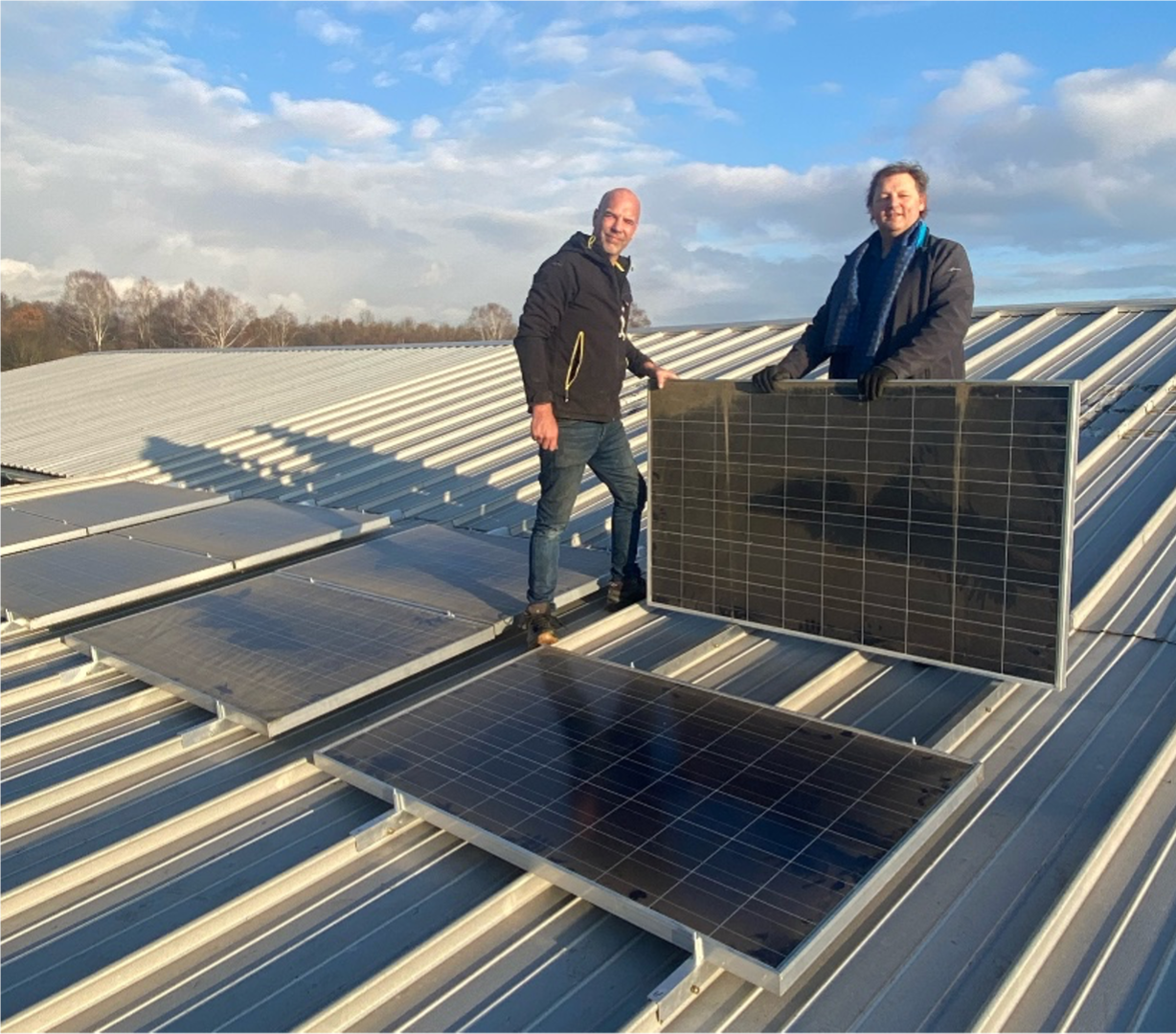 Zwei Männer montieren Solarmodule auf dem Hallendach des LSV Pfaffenhofen
